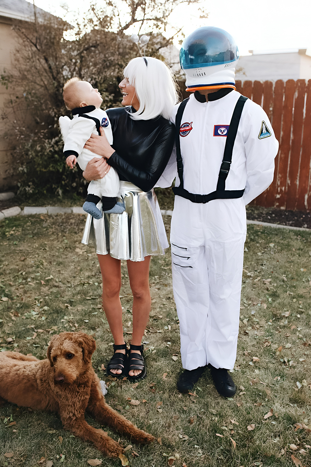 Family wearing astronaut costumes with the baby in a tiny space suit