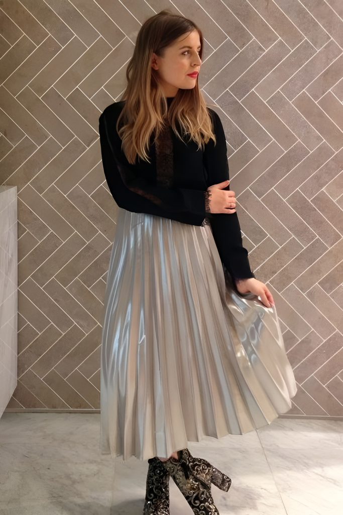 Metallic pleated skirt styled with a fitted sweater, comfortable festive outfit