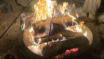 Outdoor bonfire gathering with hot drinks and a good atmosphere